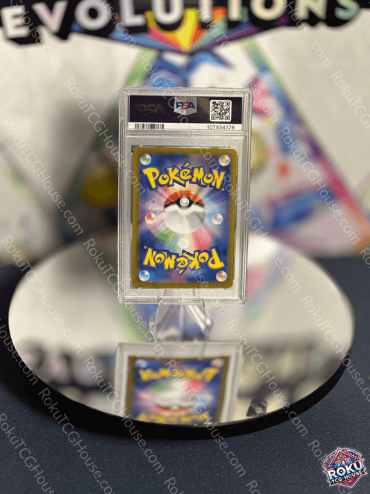 Back of a PSA graded Pokemon card displayed on a reflective surface, featuring the iconic Pokemon logo.