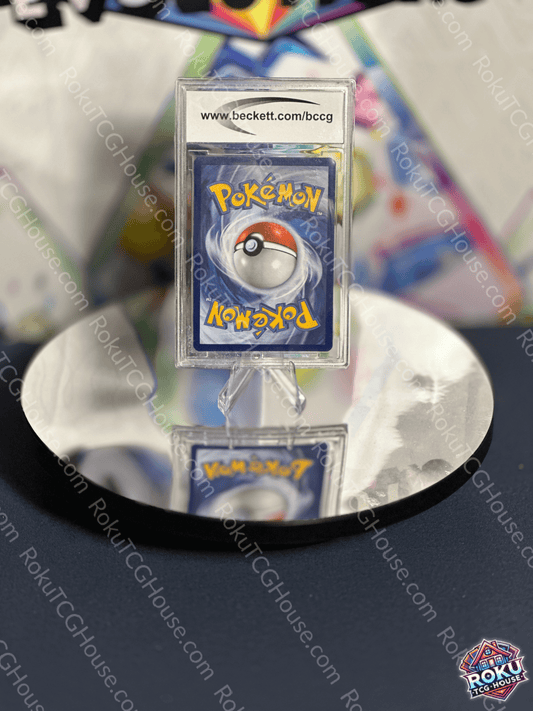 Pokémon card back featuring iconic Pokéball design, displayed on a reflective surface.