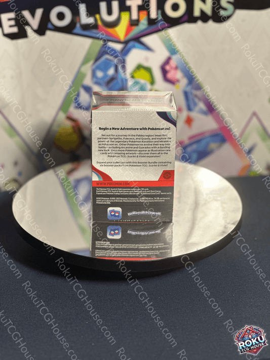 Scarlet & Violet: Base Booster Bundle box displayed on a reflective surface, showcasing Pokémon card details.