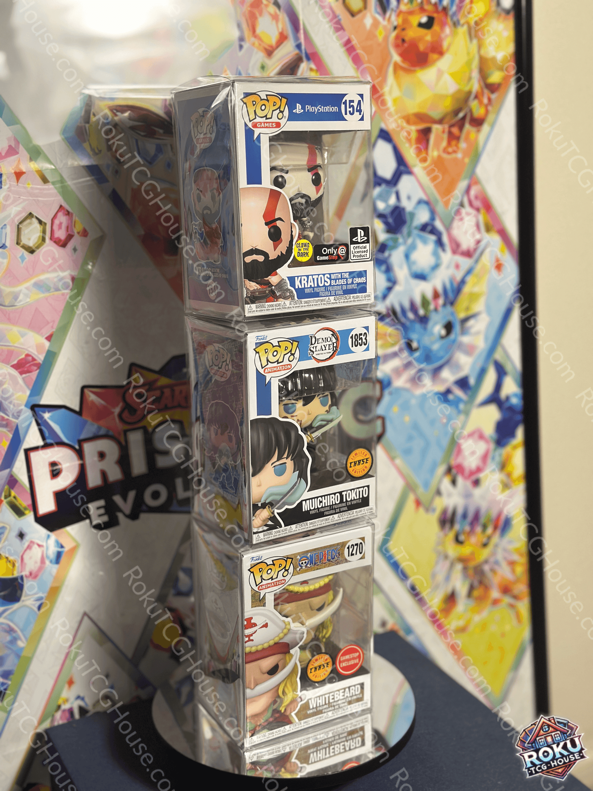 Stack of three Funko Pop! Vinyl figures in protective cases displayed on a stand against a colorful background.