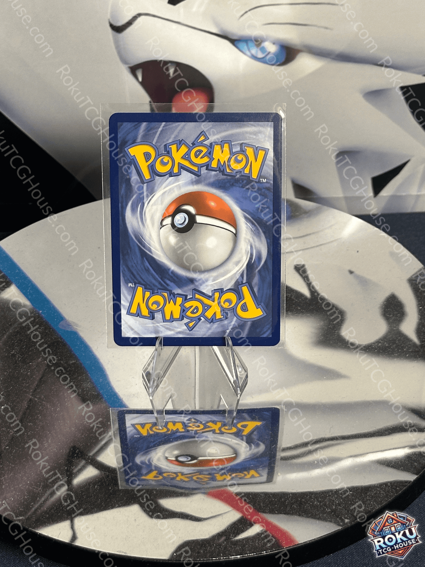 Pokémon card featuring a Poké Ball on a reflective surface, showcasing vibrant artwork with a blue background.