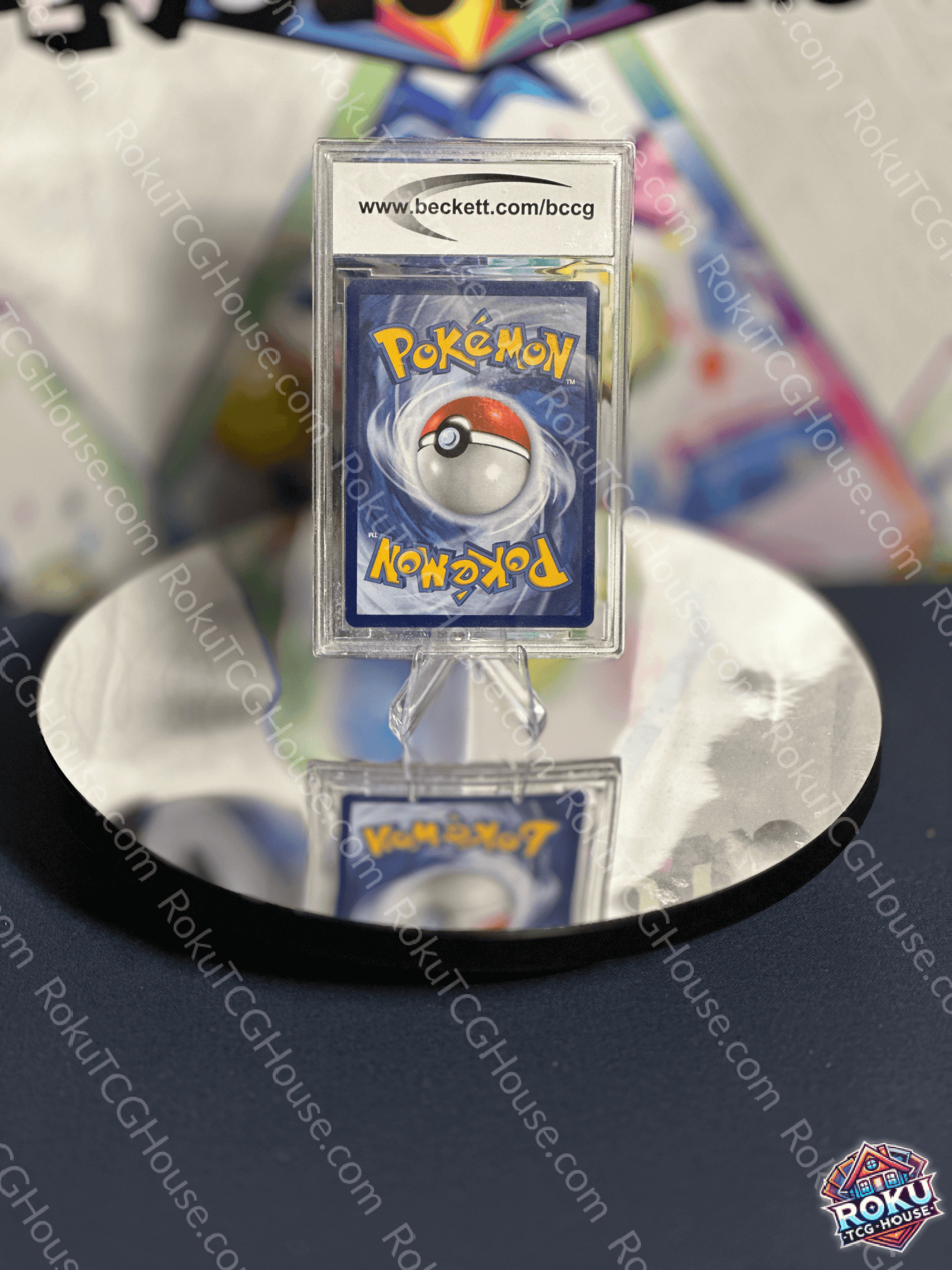 Pokémon card back featuring iconic Pokéball design, displayed on a reflective surface.