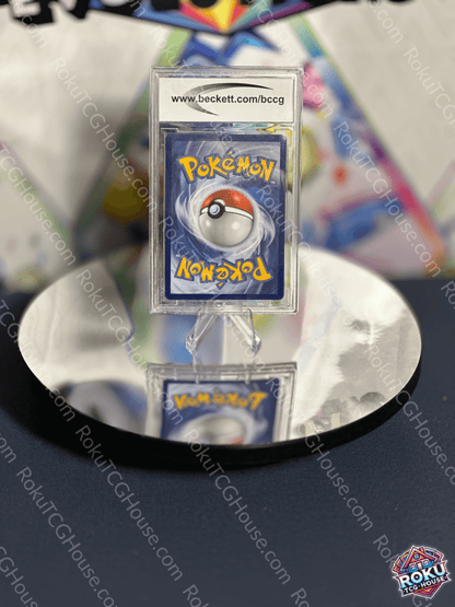 Pokémon card back featuring iconic Pokéball design, displayed on a reflective surface.