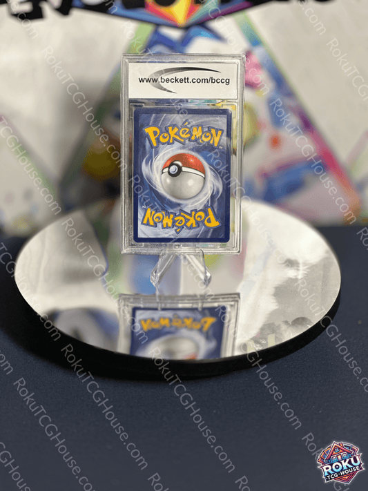 Pokémon card back featuring iconic Pokéball design, displayed on a reflective surface.
