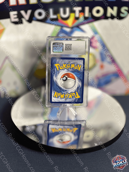 Pokémon card displayed on a reflective surface, featuring a Pokéball and vibrant colors from the Evolutions set.