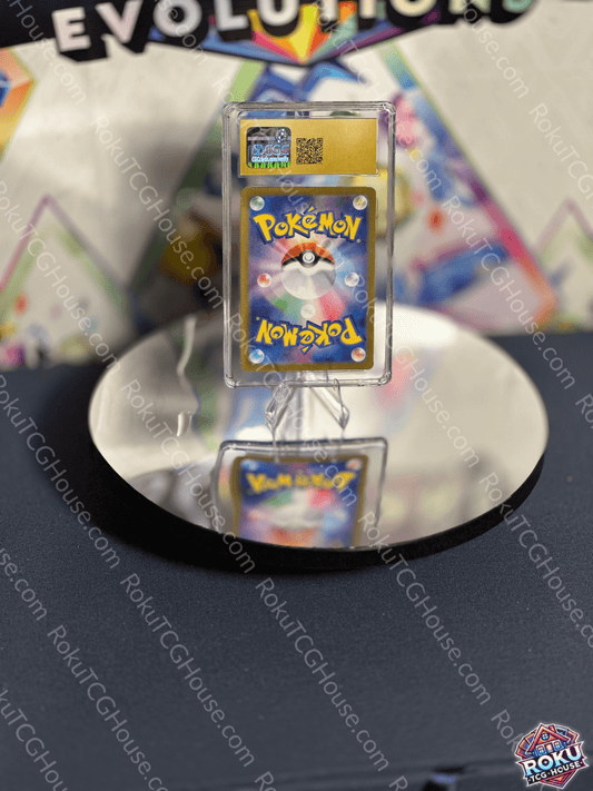 Close-up of a graded Pokémon card displayed on a reflective surface, showcasing vibrant artwork and high quality.