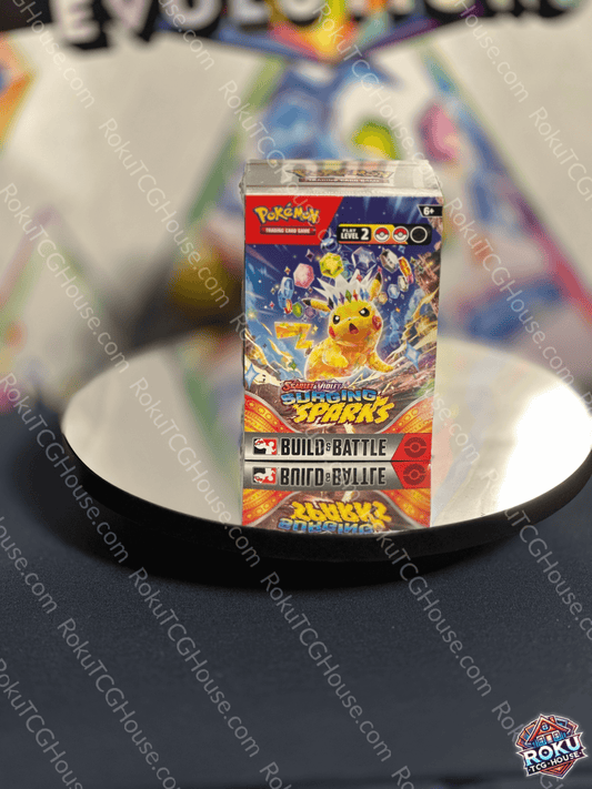 Surging Sparks Build & Battle Box featuring Pikachu on a reflective surface, perfect for quick deck building.