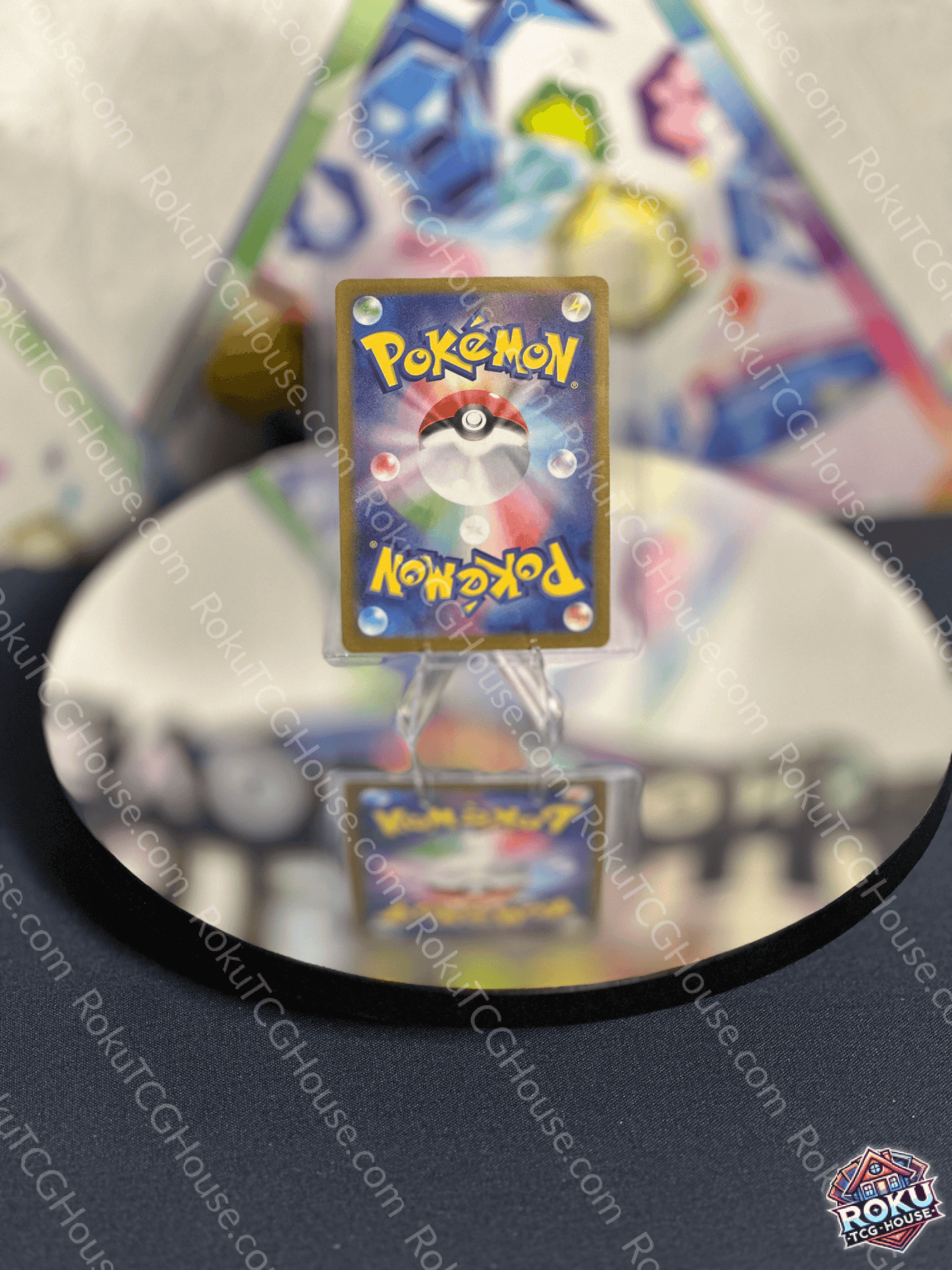 Back view of a Pokémon card on a reflective surface, showcasing the iconic logo and detailed design.