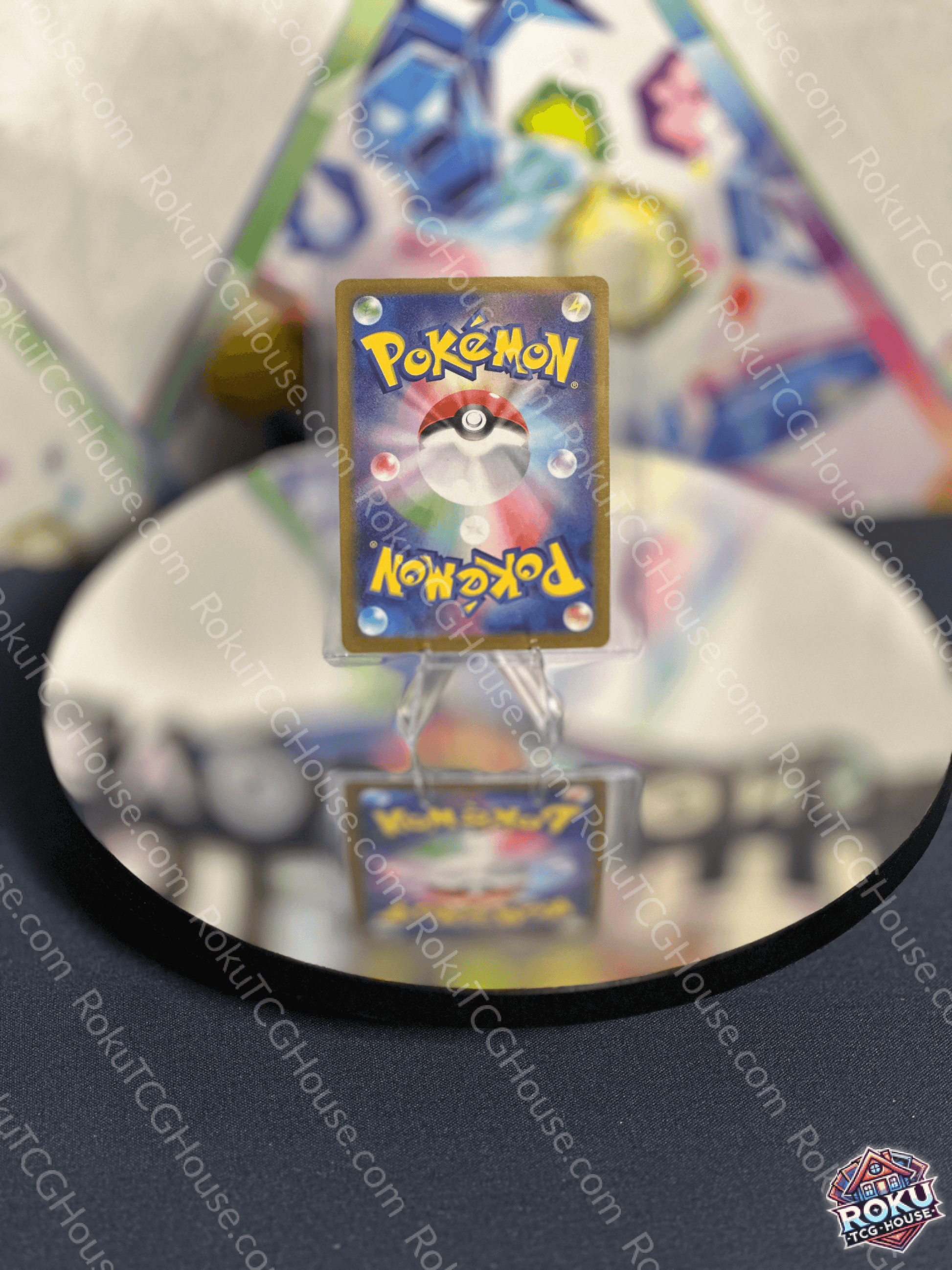 Back view of a Pokémon card on a reflective surface, showcasing the iconic logo and detailed design.