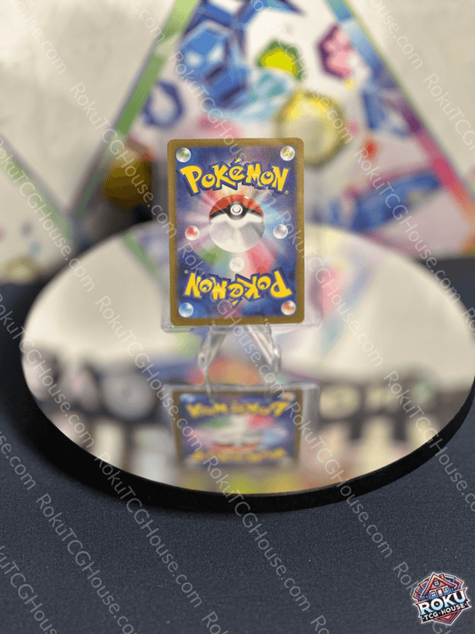 Back view of a Pokémon card on a reflective surface, showcasing the iconic logo and detailed design.