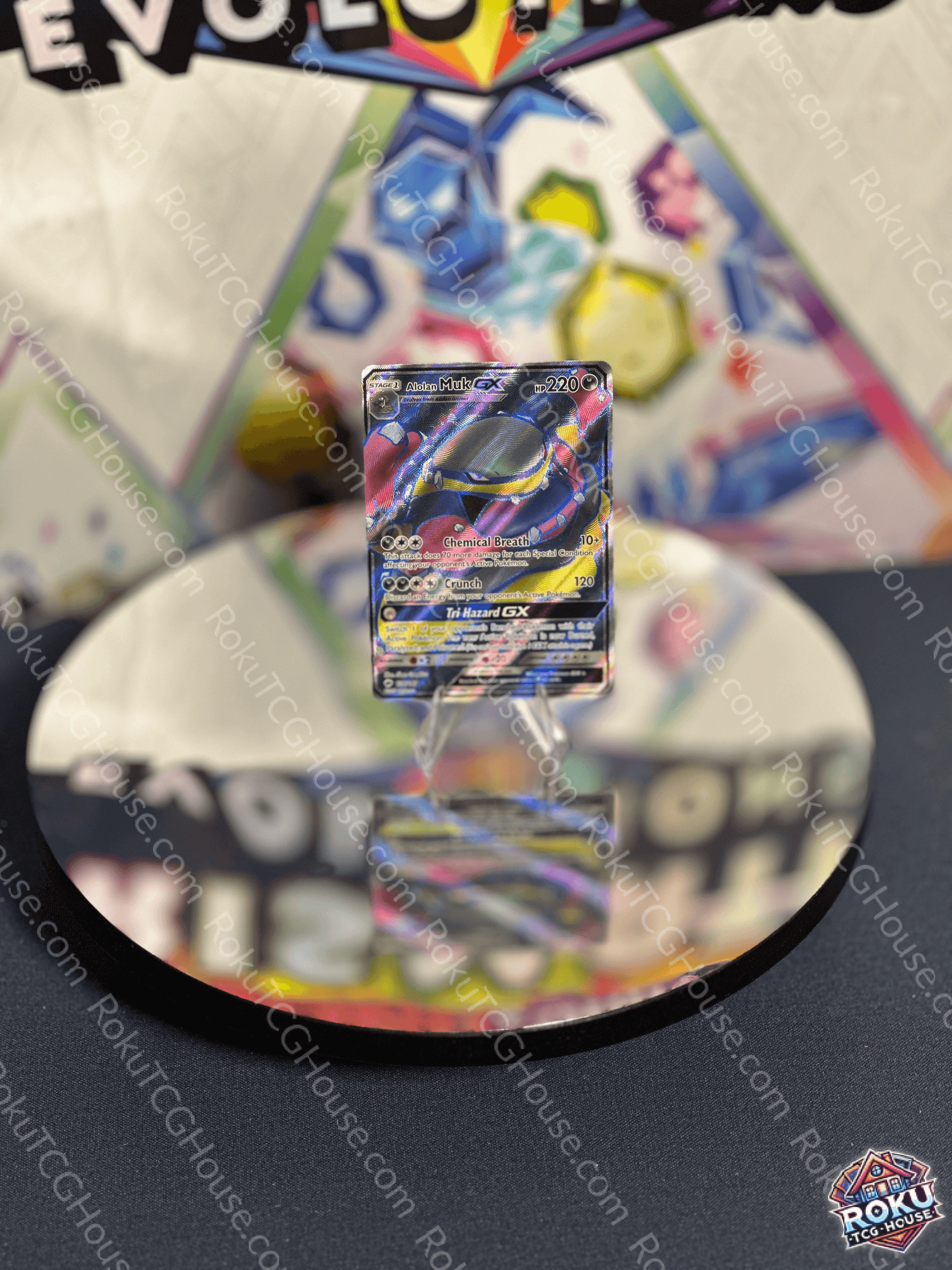 Alolan Muk GX card from Burning Shadows displayed on a reflective surface, showcasing its vibrant artwork.